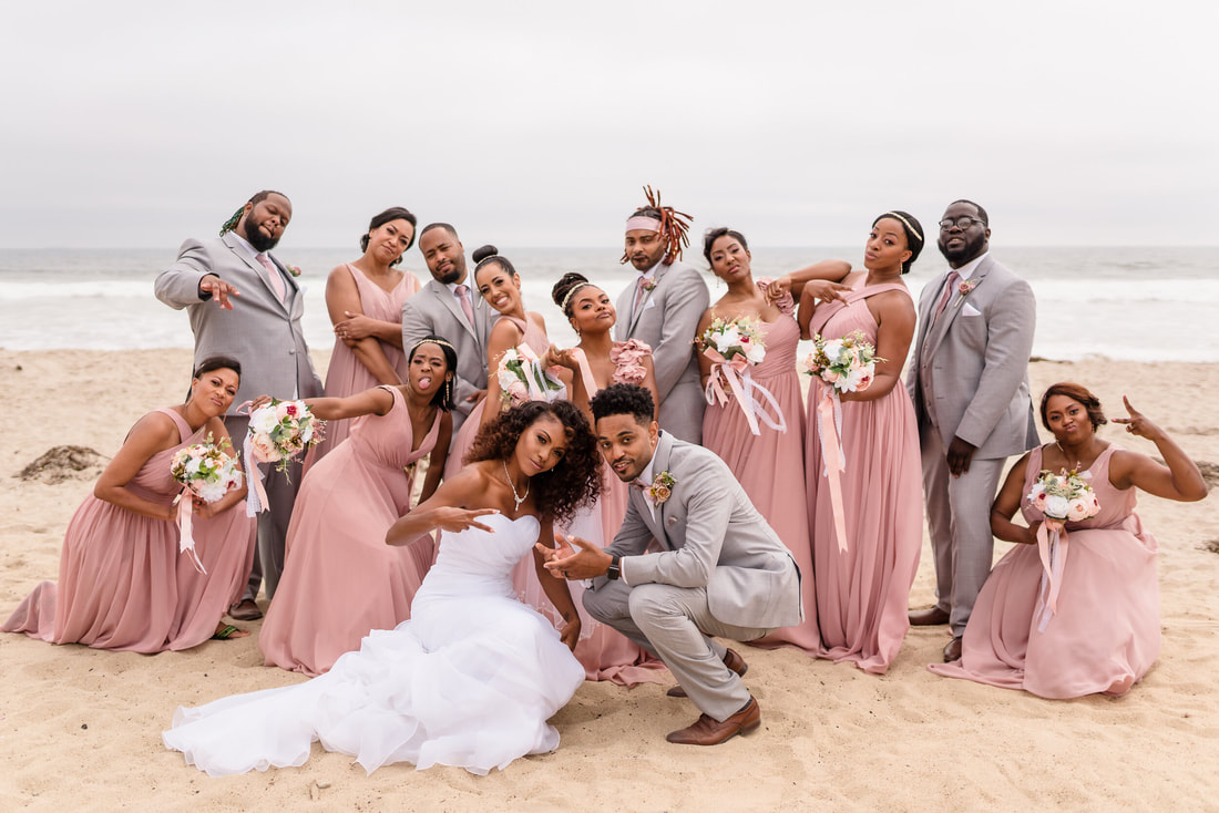 Bride and groom with their bridal party posing on the beach taken by San Diego Wedding Videographer One in a Million Films